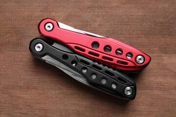 Modern compact portable multitool on wooden table, top view