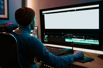 Attractive Male Video Editor Works with Footage or Video on His Personal Computer, he Works in...