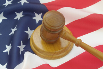 Wooden judge gavel on USA flag. Laws, court and legal system of United States concept.