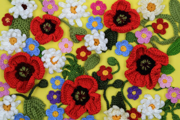 Crafted multicolored flowers and leaves on yellow background 