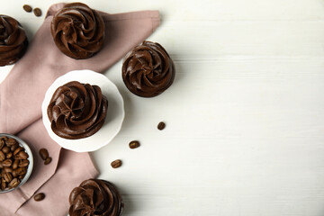 Flat lay composition with delicious chocolate cupcakes on white wooden table. Space for text