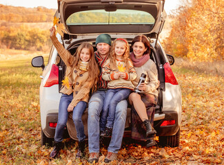 Family sitting in car trunk
