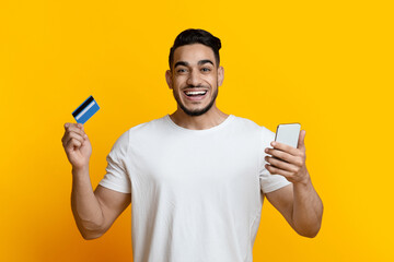 Happy arab guy with smartphone and credit card