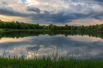 Reflections of trees and sky in the pond in the late afternoon