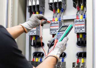 Electrician engineer work tester measuring voltage and current of power electric line in electical...