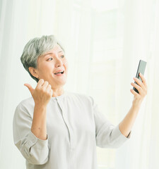 Senior asian woman using or talking on her mobile phone.