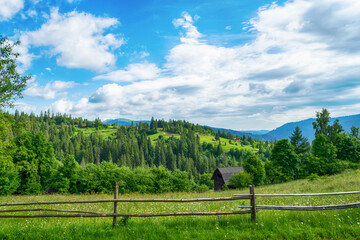 Beautiful mountains. Wooden fence from a log house. Small wooden house. Carpathians. Ukraine.