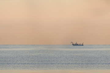 fishing boat at dawn at sea
