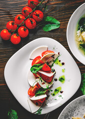 Italian Caprese salad with tomato and cheese in white plate