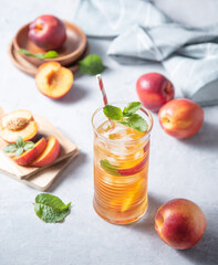 cool peach tea with mint and ice in a glass on a blue background. Top view  and close up