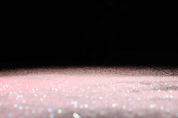 Shiny pink glitter on black background, space for text. Bokeh effect
