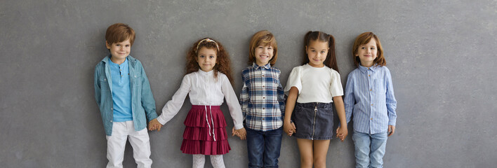 Banner with portrait of happy little kids in casual wear. Group of adorable children in new neat...