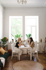 Mom, I can share everything with you. Mother and her daughter are sitting in the kitchen having a cup of tea and talking.