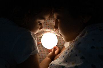 Two sisters sleeping by a light to chase away their fears of the dark