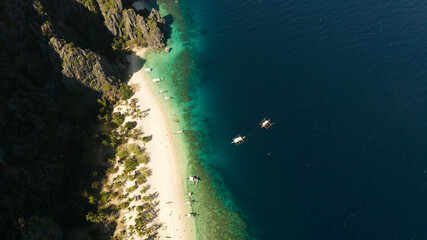 aerial drone tropical island and sand beach with palm trees. Malajon Island, Philippines, Palawan. tourist boats on coast tropical island. Summer and travel vacation concept. beach and blue clear sea