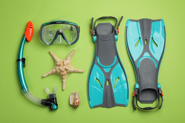 Flat lay composition with beach objects on green background