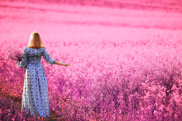 girl in a field of lilac flowers in lavender colors, violet and pink landscape, happy and harmony