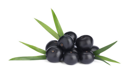 Pile of fresh ripe acai berries and green leaves on white background