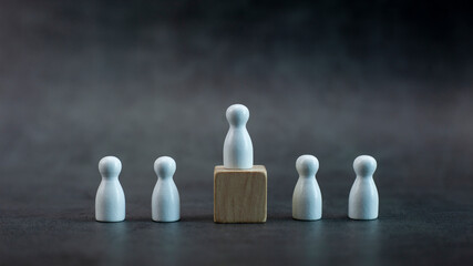 white wooden person model among people on black background, Leadership concept.