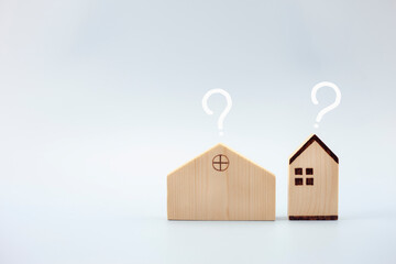 House model with question marks on blue background, planning to buy property, loan concept