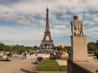 Fototapeta na wymiar Paris, FRANCE - May 2021: The Eiffel Tower, the symbol of Paris, front view, tourists relaxing against the background of a non-working fountains