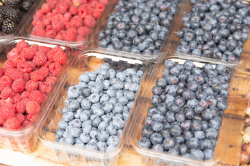 fresh berries are on sale. raspberries, blueberries, blueberries, blackberries