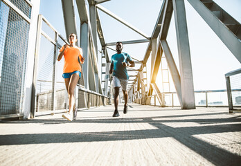Running couple jogging training outside on run - Black man and caucasian woman runner and fitness...
