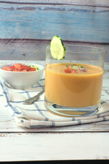 Spanish gazpacho or salmorejo soup on a white wooden table.