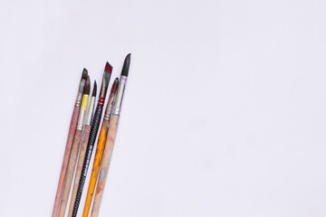 Paint brushes on a white background. Stained with paint