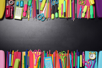 Flat lay composition with school stationery on black chalkboard, space for text