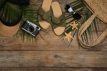 Flat lay composition with beach objects on wooden background, space for text