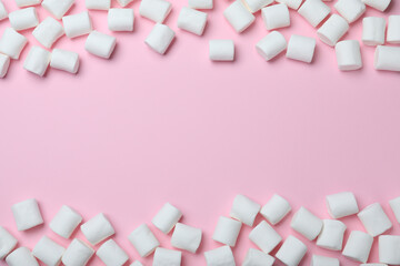 Delicious puffy marshmallows on pink background, flat lay. Space for text