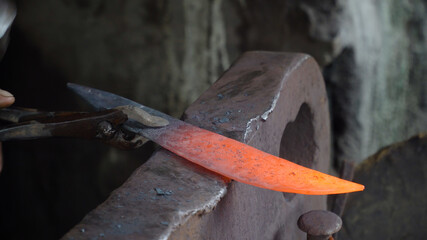 Red hot metal blank in the forge on the anvil. Anvil in the forge