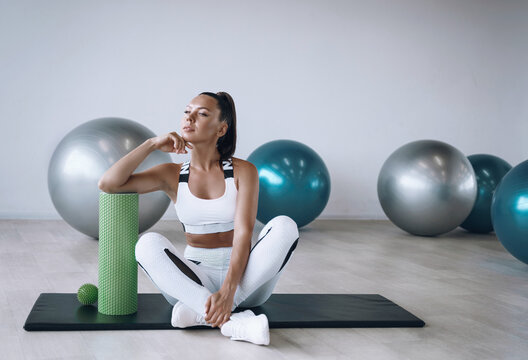 Black Woman In A White Tracksuit In The Gym With Fit Foam Roller