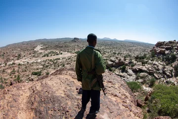 Foto op Canvas Back view of a Somaliland police force overlooking the wilderness from the top of the hill © Yz-Wu