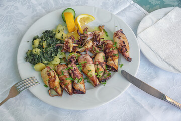 Balkan cuisine. Dish with grilled squids with chard leaves ( blitva ) and potatoes
