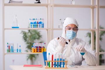 Young male chemist working at the lab during pandemic