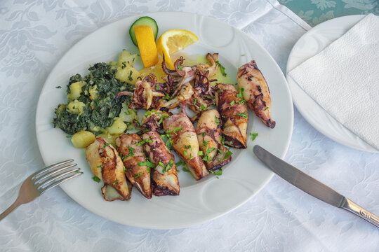 Balkan cuisine. Dish with grilled squids with chard leaves ( blitva ) and potatoes