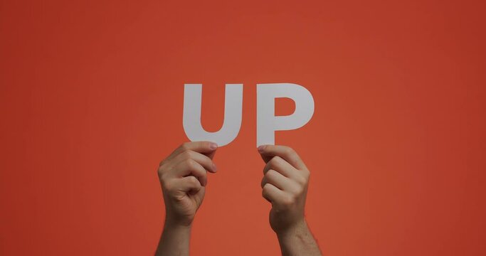 Hands showing word up of english language. Man shows letters made of carved paper