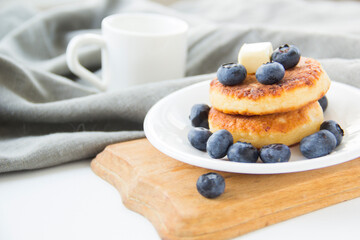 A healthy breakfast of pancakes, berries, butter, and honey. Creative atmospheric decoration