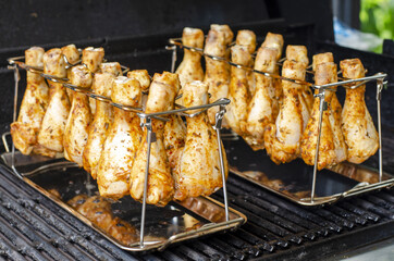 grilled chicken wings on the grill,  golden chicken drumsticks close up, grilling in a grill stand
