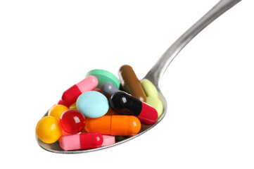 Spoon with different colorful pills on white background