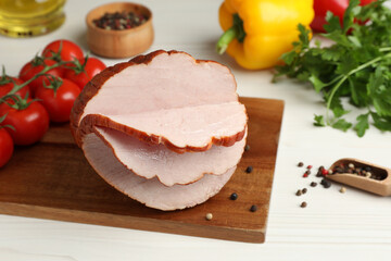 Delicious cut ham and vegetables on white wooden table