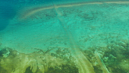 Sea water surface in lagoon, background with sun light reflection, copy space for text, aerial view. Top view transparent turquoise ocean water surface. background texture