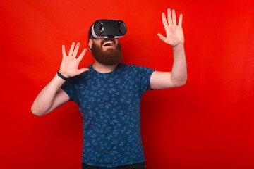 Fototapeta na wymiar Photo of amazed and excited bearded man having Virtual Reality Experience with VR helmet