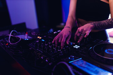 the hands of a dj girl at the music control panel