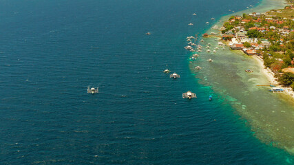 Fototapeta na wymiar Shore with hotels near coral reef and diving boats, Moalboal, Philippines. Aerial view, Summer and travel vacation concept.