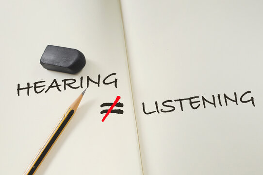 Hearing not equal listening written on book with pencil and eraser. Communication with understanding empathy concept and soft skill idea