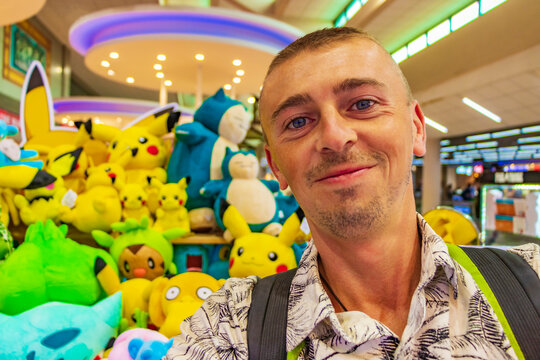 Tourist with colorful Pokemon Pikachu plush toys Bangkok airport Thailand.