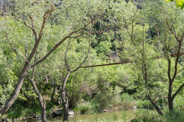 old iron suspension bridge over the stream